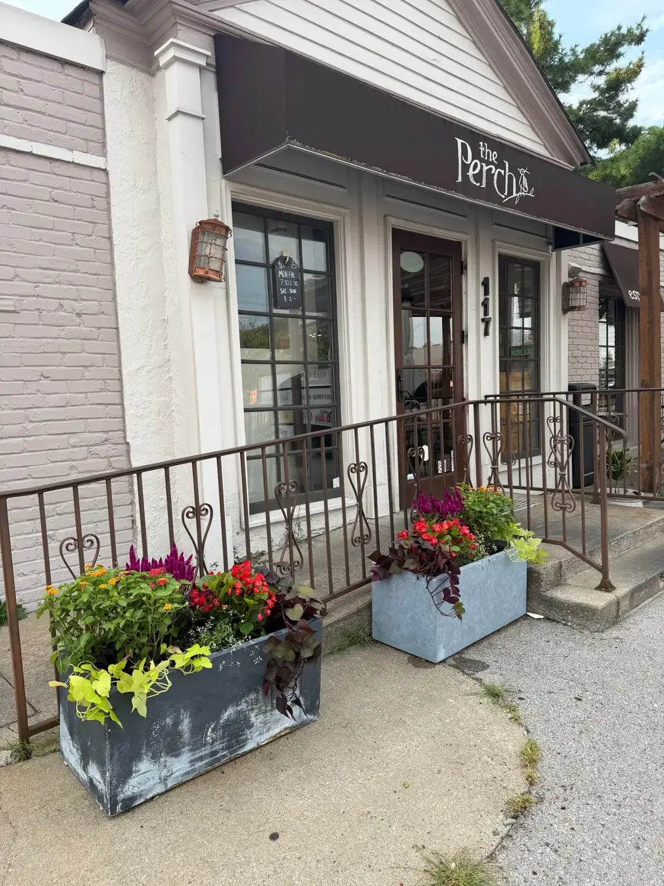 Two trough planters with celosia, begonias, lantana, and sweet potato vine at the entrance of The Perch cafe.